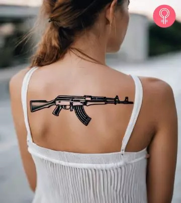 An AK-47 tattooed on the upper back