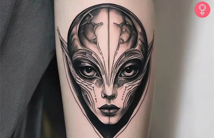 A woman with an alien head tattoo on the upper arm.