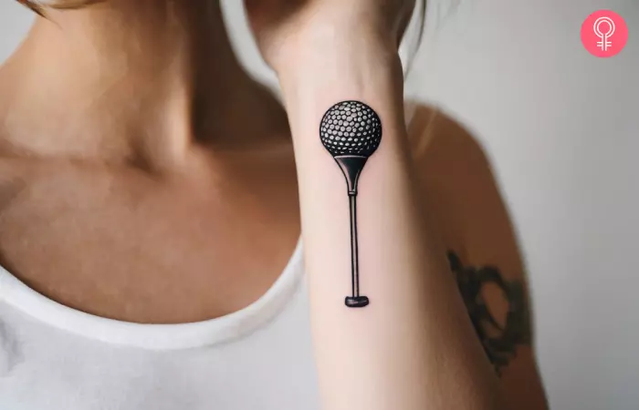 A woman with golf tee tattoo on the wrist