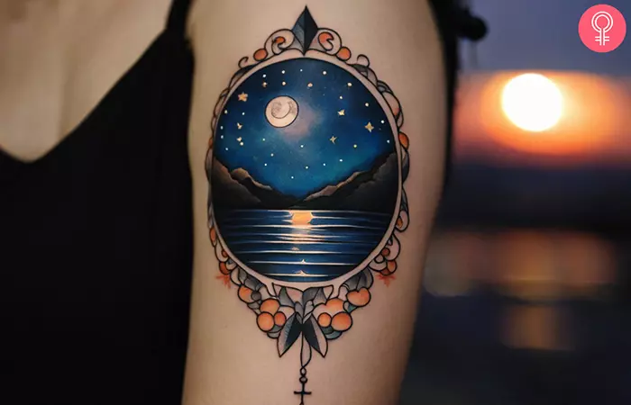 A woman with night sky moon and water tattoo on her upper arm