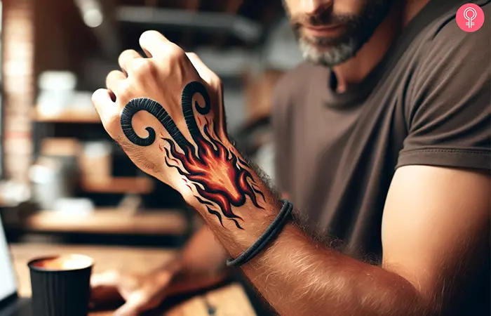An Aries fire tattoo on the hand of a man