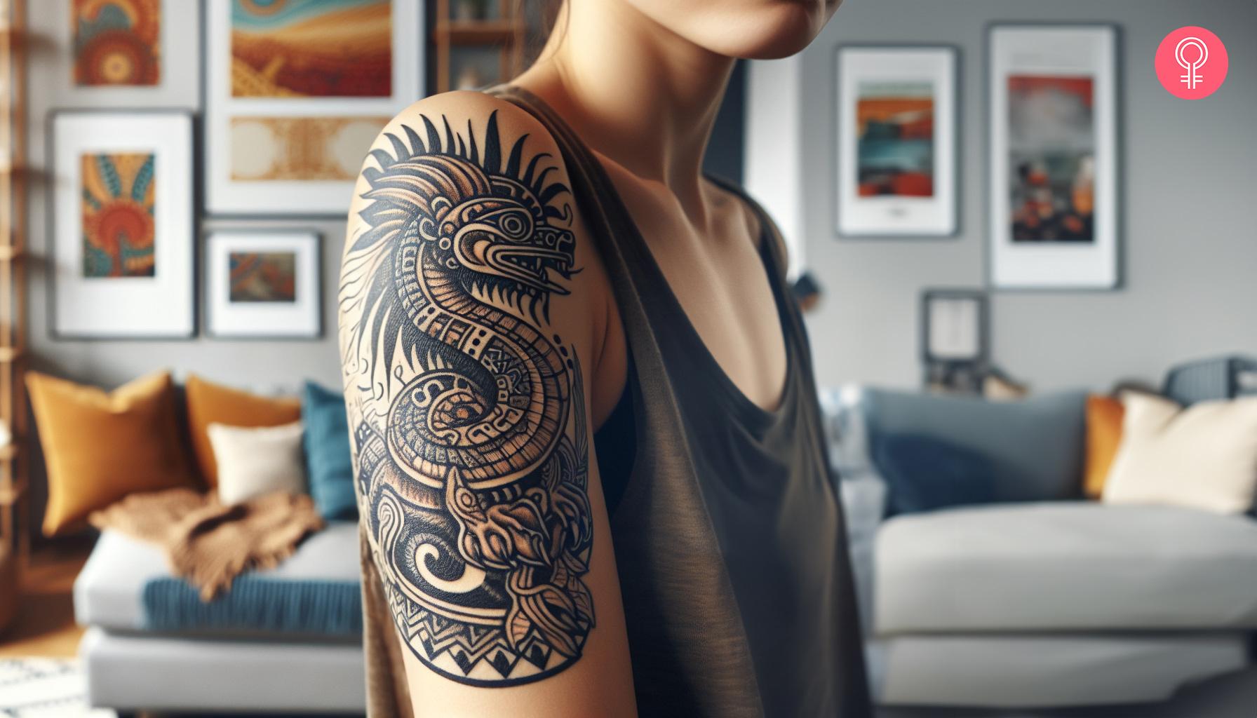 An Aztec dragon tattoo on a woman's upper arm