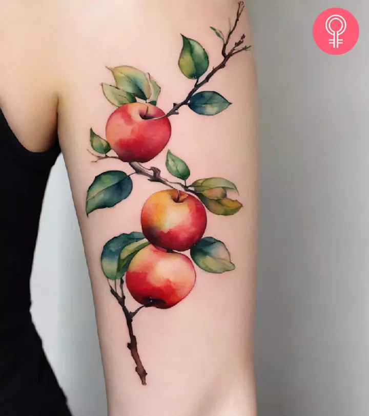 An apple tattoo on a woman’s arm