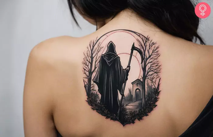 An upper back tattoo showing a Grim Reaper at the graveyard