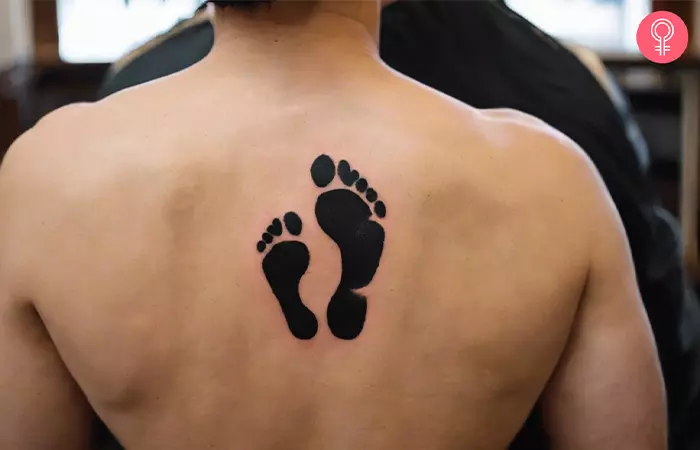 Footprint silhouette tattoo on the back of a man