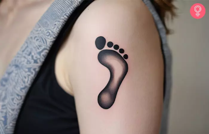 A baby footprint tattoo on a woman’s arm