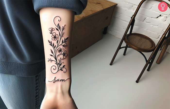 A floral baby name tattoo on the wrist