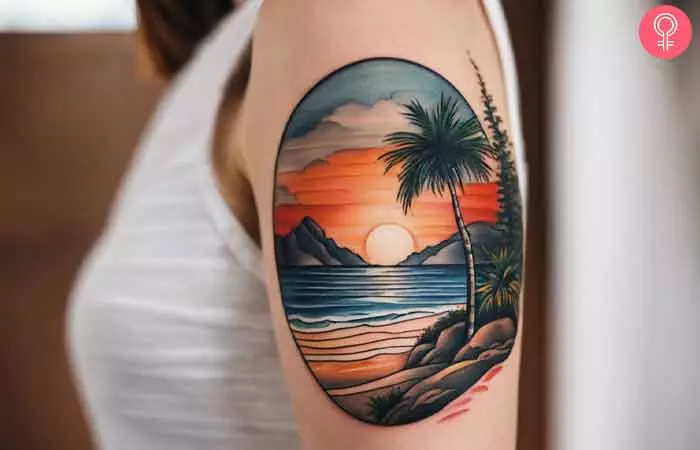 A woman with a beach landscape tattoo on her upper arm
