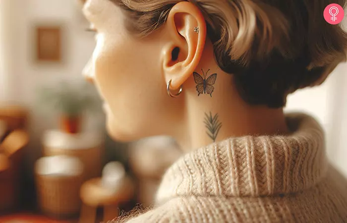 A black ink butterfly tattoo behind the ear