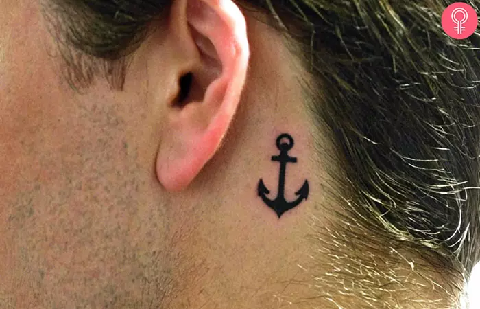 A behind the ear anchor tattoo on a man