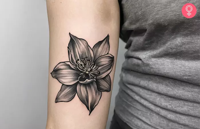 A black and white daffodil tattoo on the upper arm