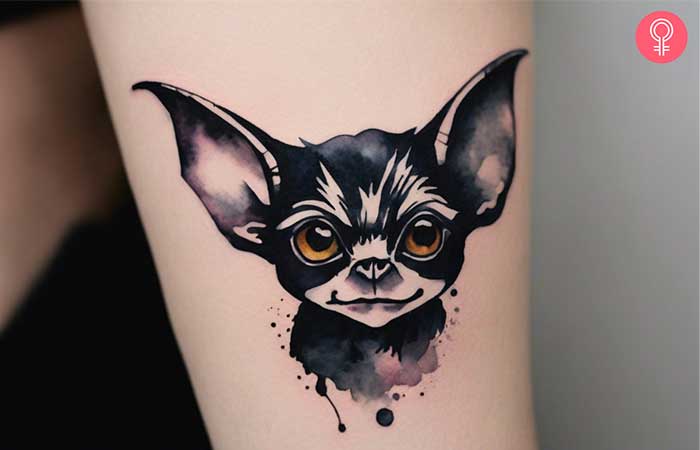 A black and white gremlin arm tattoo