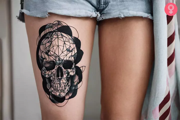 Woman with trippy black and white skull tattoo on her thigh
