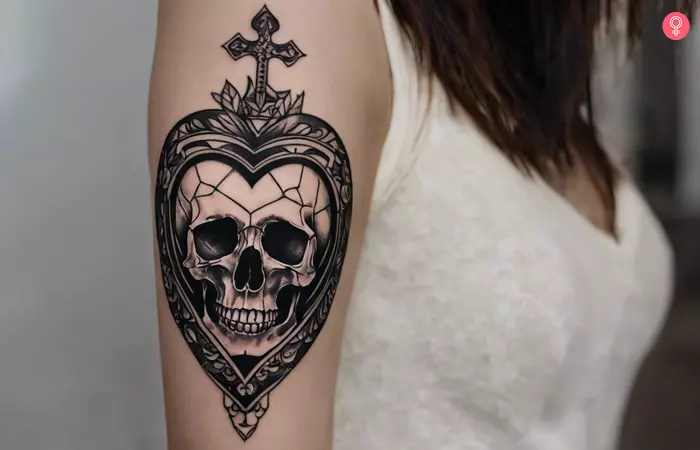 Woman with a black heart and skull tattoo on the arm