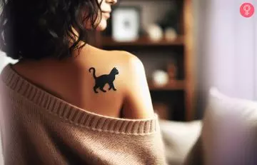 Black cat Halloween tattoo on the shoulder blade of a woman
