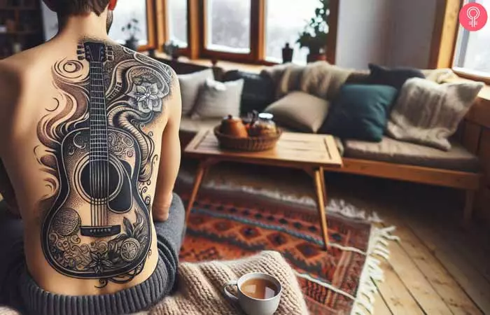 A man with a blackwork guitar tattoo on his back 