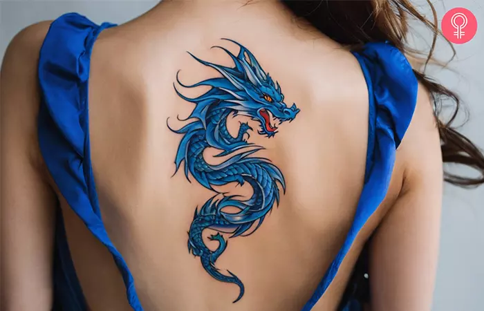A woman with a blue dragon tattoo on her back