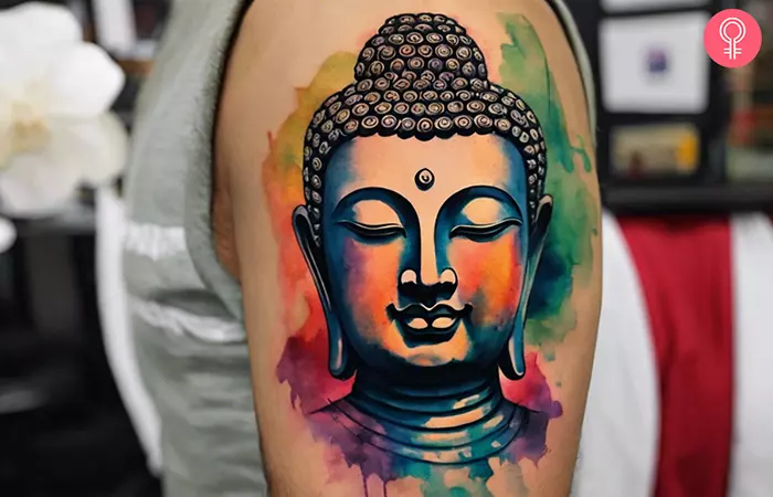 Buddha face tattoo on the arm of a man