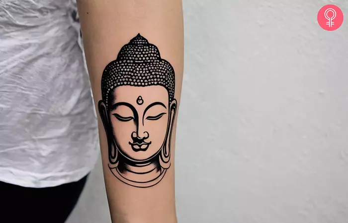 Buddha tattoo on the arm of a woman