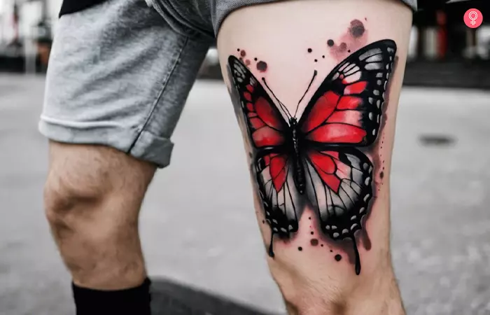 A black and red butterfly tattoo on a man’s thigh
