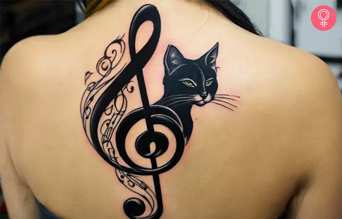 Woman with a cat treble clef tattoo on her back