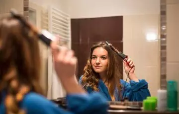 woman curling her layered hair