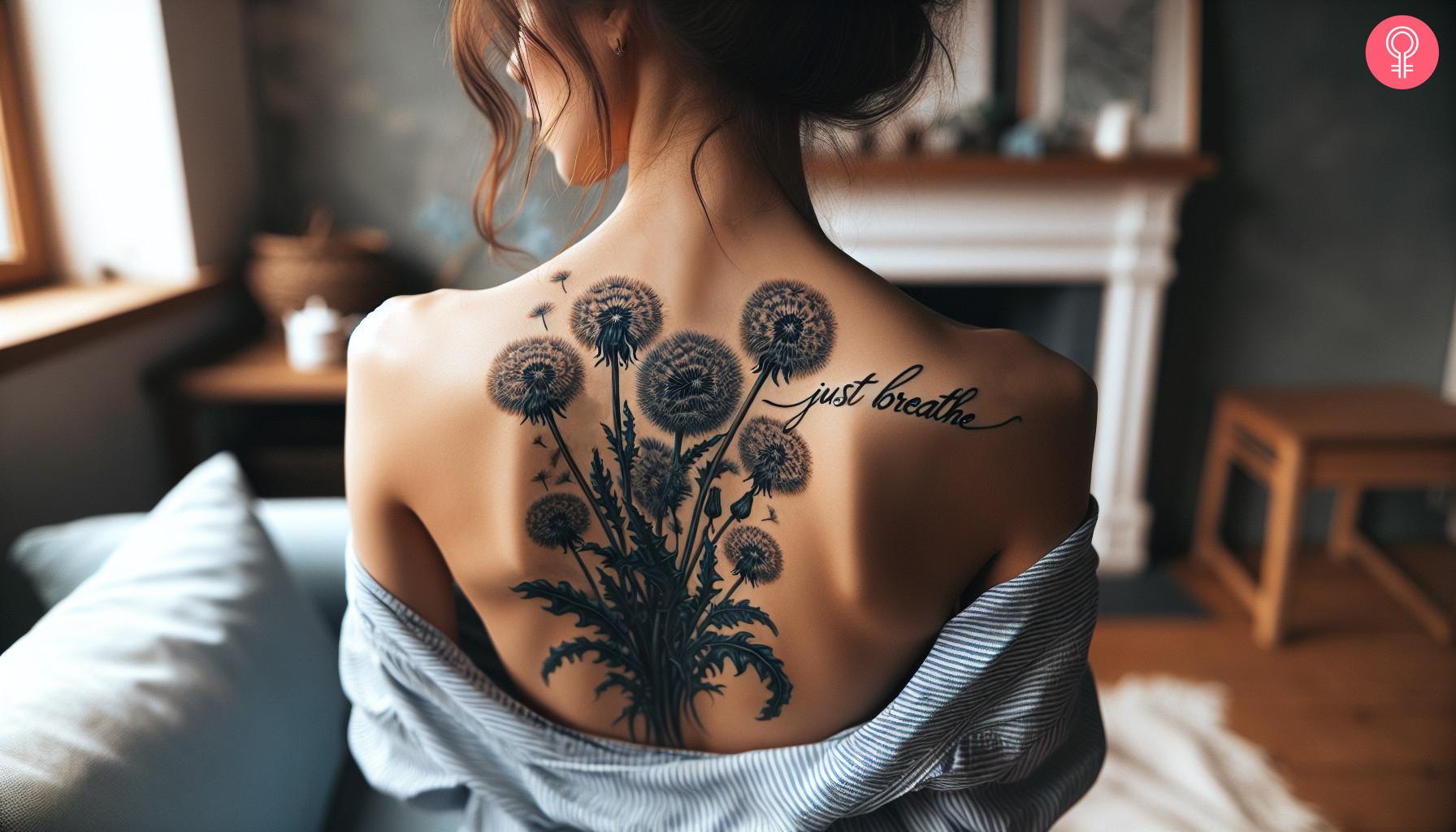 Dandelion tattoo with the words 'Just Breathe' on a woman's back