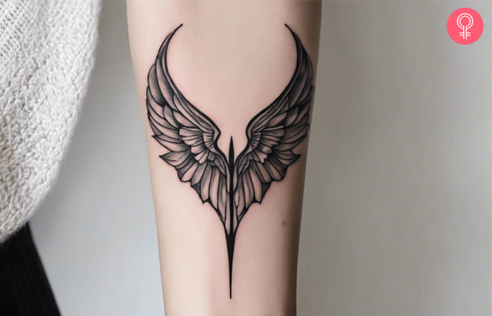 A woman with a demon wings tattoo on the arm