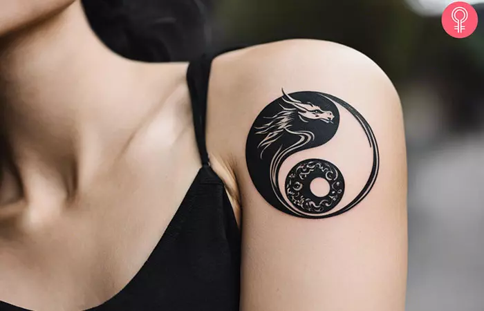 A dragon yin yang tattoo on the upper arm