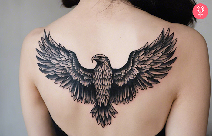 A woman with an eagle wings tattoo on the upper back 