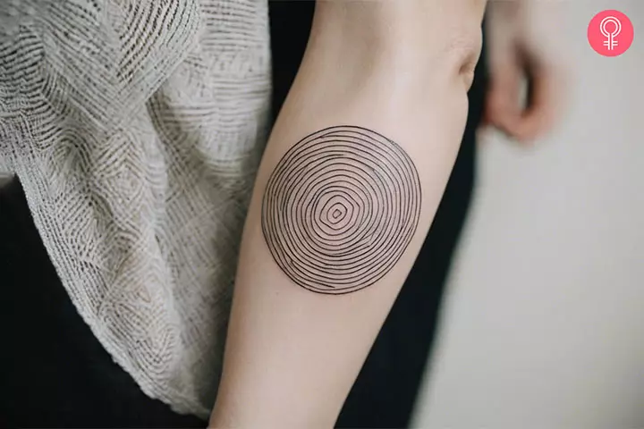 Woman with trippy line art tattoo on her upper arm