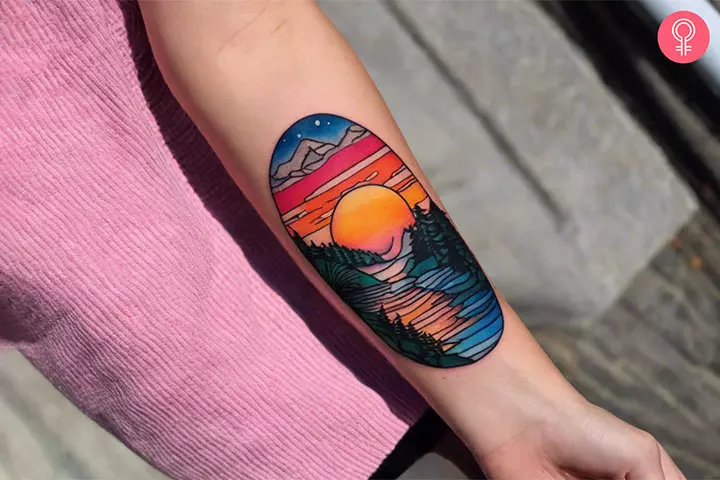 A woman with an easy psychedelic scenic tattoo on her forearm