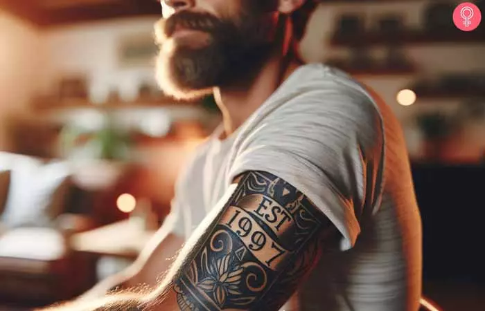 A man with an an Est. 1997 tattoo on the upper arm