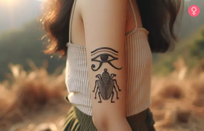 An eye of Horus and scarab tattoo design on the upper arm