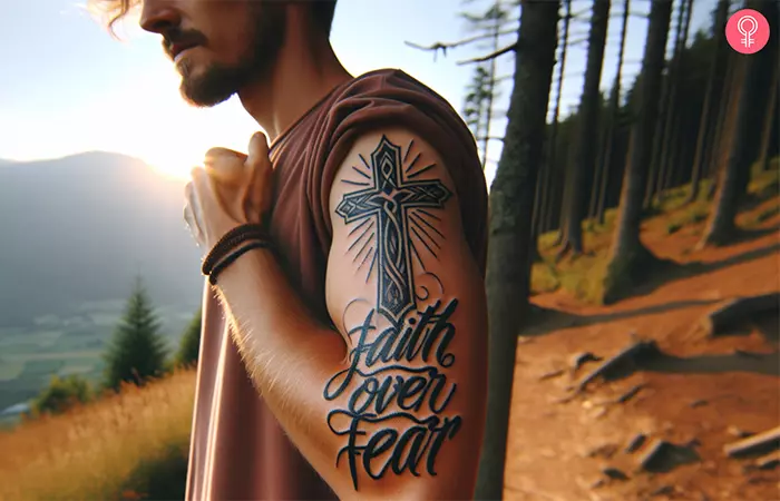 A faith over fear tattoo with a cross on the upper arm