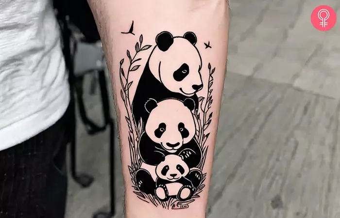 A panda family forearm tattoo in black ink