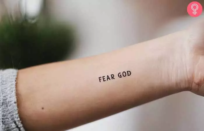 A woman with a fear god tattoo on her forearm