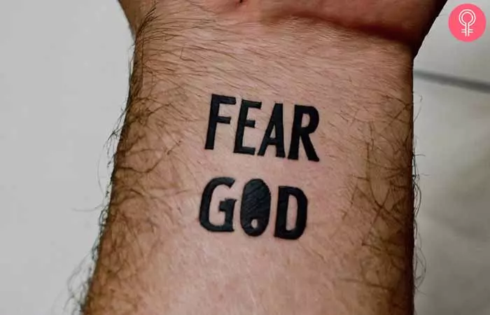 A man with a fear god tattoo on his wrist