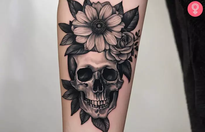 A woman with a skull and flower grayscale tattoo on her forearm