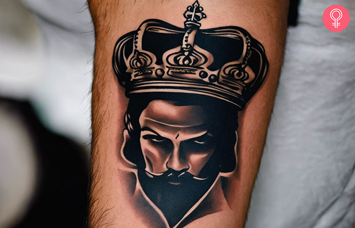 A gangster king crown tattoo design on the lower arm of a man