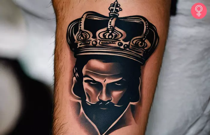 A gangster king crown tattoo design on the lower arm of a man