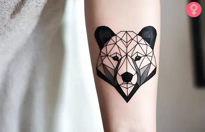 A woman with a geometric bear tattoo on her arm