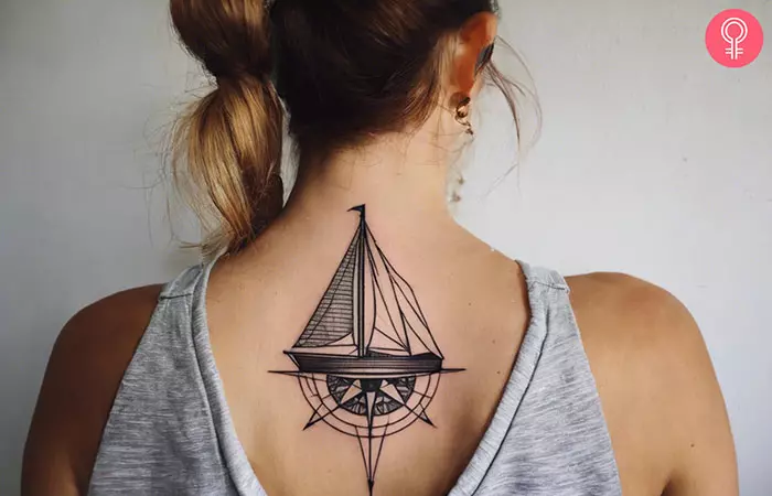 Woman with geometric sailboat tattoo with compass design on her back