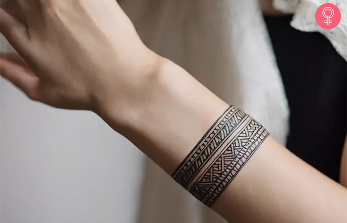 A woman with a geometric tribal tattoo on her lower arm