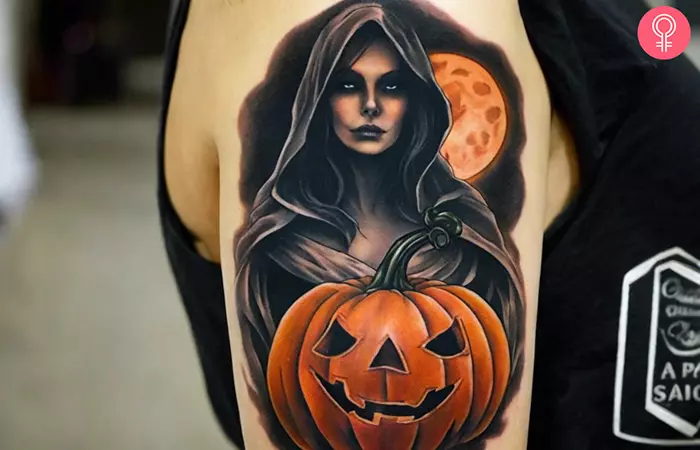 Halloween ghost holding a pumpkin tattoo on the upper arm