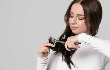 A woman trying to do the feathered cut