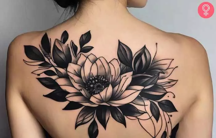 A woman with a flower blackwork tattoo on her upper back 