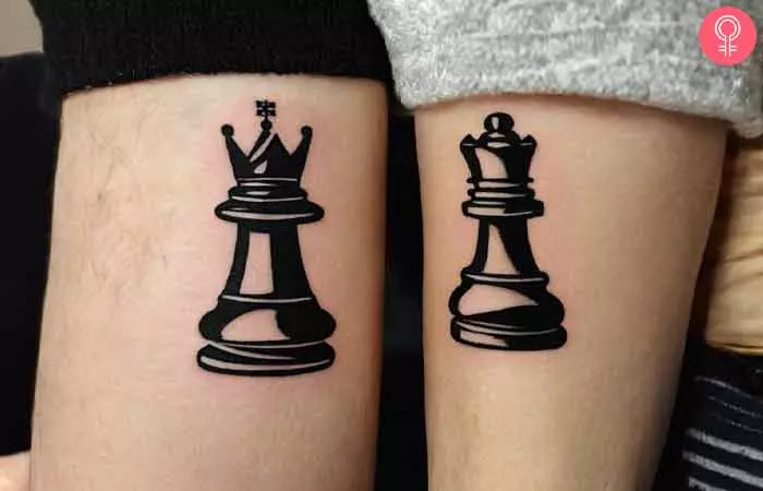 A couple sporting a king and a queen chess piece tattooed on their arms