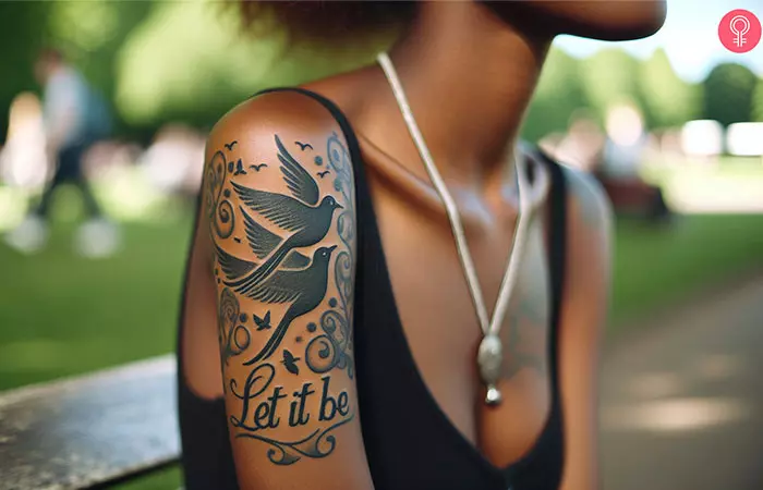 A woman flaunting a let it be tattoo with birds