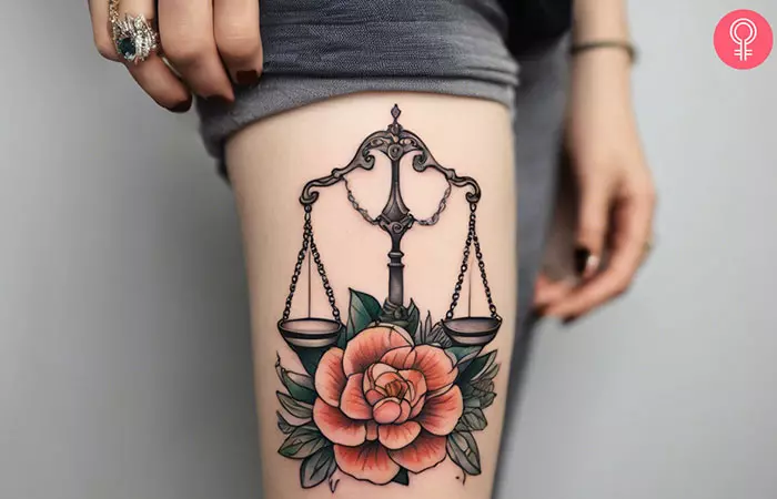 A woman with a Libra and a flower tattoo on her thigh